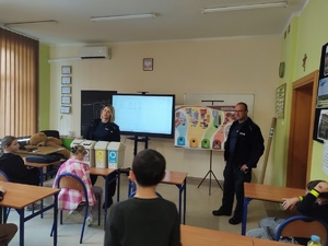 policjanci rozmawiają z uczniami w tle klasa