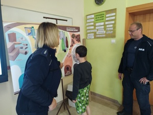 policjanci rozmawiają z uczniami w tle klasa