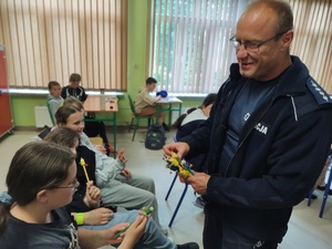 policjanci rozmawiają z uczniami w tle klasa