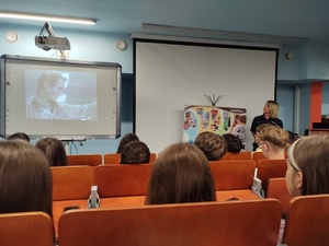 policjantka rozmawia z młodzieżą w tle sala