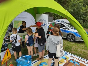 policjanci rozmawiają z dziećmi w tle namiot i policyjne gadżety