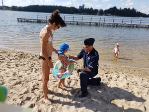 policjant rozmawia z dziećmi na kąpielisku