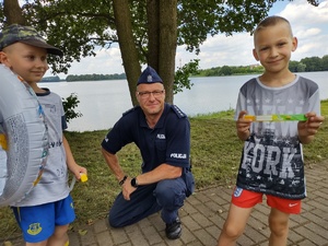 policjant rozmawia z dziećmi na kąpielisku