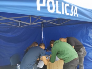 osoby przed oddaniem krwi wypełniają dokumentację w tle wnętrze namiotu