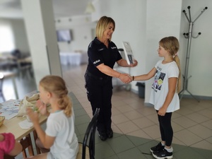 policjantka wręcza nagrody, w tle sala