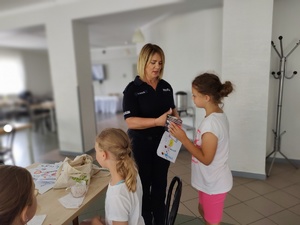 policjantka wręcza nagrody w tle sala