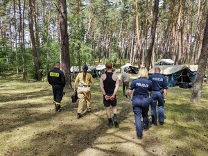 służby kontrolują obóz w tle las