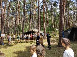 służby kontrolują obóz w tle las