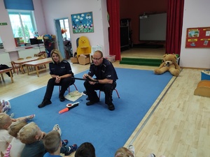 policjanci rozmawiają z dziećmi w tle sala