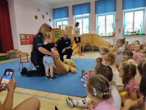 policjanci rozmawiają z dziećmi w tle sala
