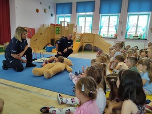 policjanci rozmawiają z dziećmi w tle sala