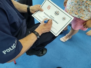 policjanci rozmawiają z dziećmi w tle sala