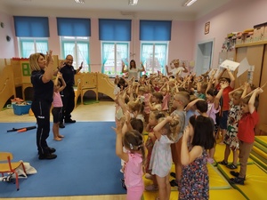 policjanci rozmawiają z dziećmi w tle sala