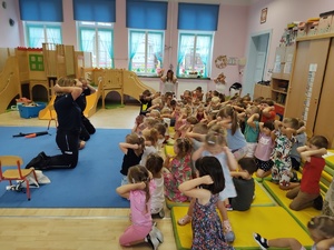 policjanci rozmawiają z dziećmi w tle sala