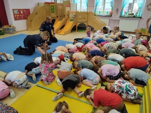 policjanci rozmawiają z dziećmi w tle sala