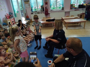 policjanci rozmawiają z dziećmi w tle sala