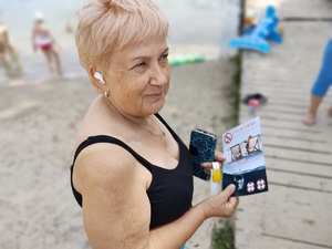 policjant rozmawia z plażowiczami w tle plaża
