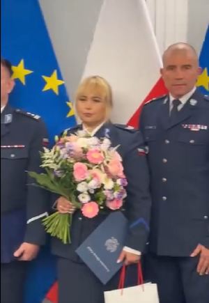 policjantka z kwiatami obok dwóch policjantów