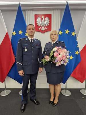 policjantka z komendantem w tle w ściana z godłem Polski