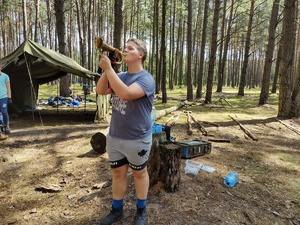 policjanci rozmawiają z harcerzami w tle las i namioty