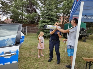 policjantka rozmawia z uczestnikami festynu w tle inne osoby teren boiska