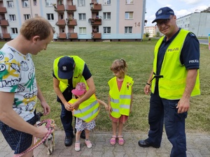 policjanci rozmawiają z małymi mieszkańcami w te osiedle