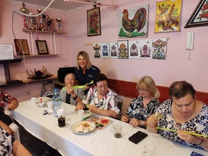 policjanci rozmawiają z seniorami w tle pomieszczenie PZN