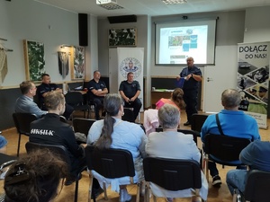 policjanci rozmawiają z mieszkańcami w tle wyposażenie wnętrza pomieszczenia