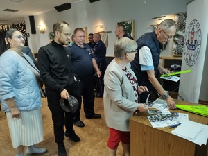 policjanci rozmawiają z mieszkańcami w tle wyposażenie wnętrza pomieszczenia