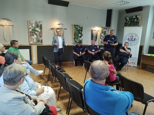 policjanci rozmawiają z mieszkańcami w tle wyposażenie wnętrza pomieszczenia