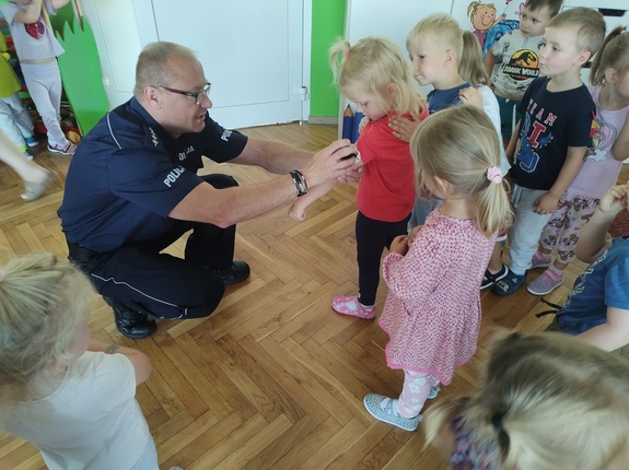 policjanci rozmawiają z dziećmi w tle wyposażenie sali