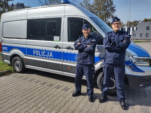 dwóch policjantów na tle radiowozu