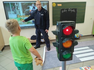 policjant rozmawia z uczniami w tle klasa
