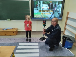 policjant rozmawia z uczniami w tle klasa