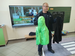 policjant rozmawia z uczniami w tle klasa