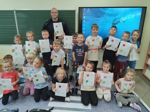 policjant rozmawia z uczniami w tle klasa