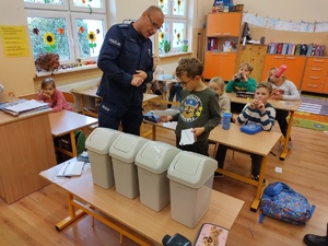 policjanci rozmawiają z dziećmi w tle sala lekcyjna
