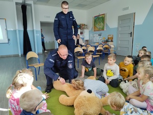 policjanci uczą dzieci pierwszej pomocy w tle sala