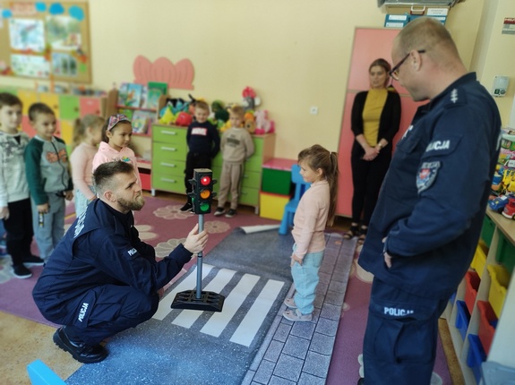 policjanci rozmawiają z dziećmi w tle sala