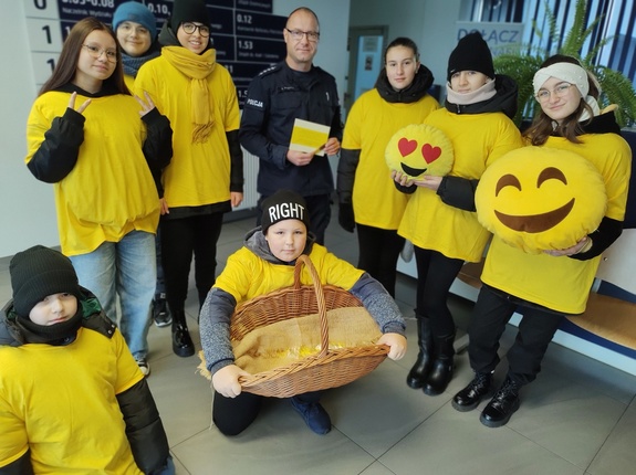 wspólne zdjęcie uczniów z policjantem w tle hol komendy