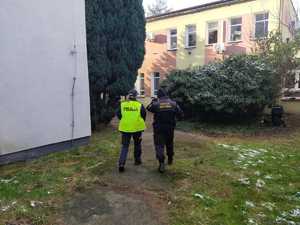policjantka i straż miejsca kontrolują miejsca przebywania osób bezdomnych w tle budynki