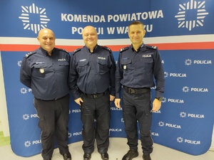 wspólne zdjęcie policjantów w tle ścianka z logo policji