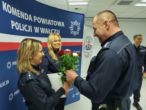 składanie życzeń i gratulacji w tle ścianka z logo policji