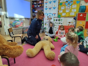 policjantka rozmawia z dziećmi w tle pluszowe misie i wyposażenie sali