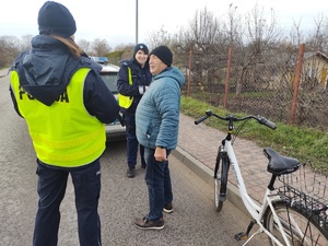 policjantki rozmawiają z rowerzystami w tle ulica
