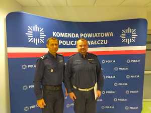 wręczenie awansu w tle ścianka z logo policji