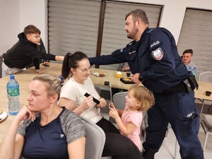 policjant wręcza odblaski w tle seniorzy i pomieszczenie