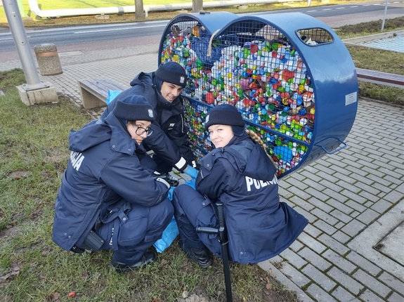 policjanci przy koszu z nakrętkami w tle parking