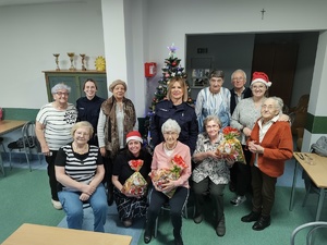 policjantki rozmawiają z seniorami w tle choinka i wyposażenie pomieszczenia