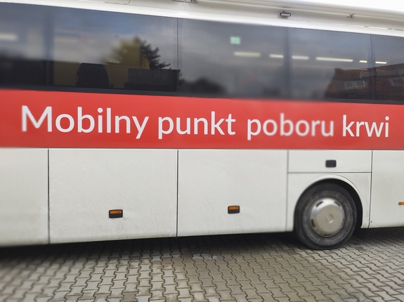 policjanci oddają krew w tle wyposażenie krwiobusa